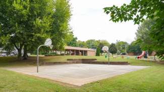 Outdoor basketball court with playground in background