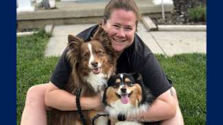 Woman smiling holding her two dogs