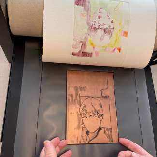 An etched copper plate sits below a colorful print of a boy's face