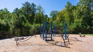 Playground equipment with climbing structures and trees in background