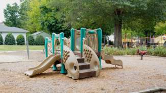 LeVelle Moton Park playground with view of play structure for ages 2 to 5 with other play structures in background