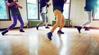 Cropped shot of a group of people dancing together in a studio