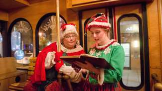 Mrs Claus and elf looking at book