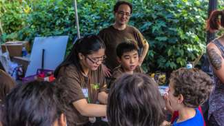 Volunteers assisting children at Bugfest event