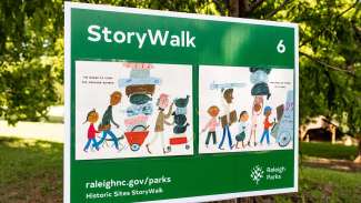 Green yard sign with illustration of people walking