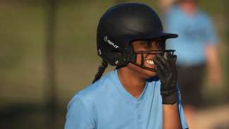 softball player wearing a helmet and smiling during the game