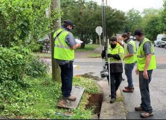 Stormwater staff inspecting storm drain