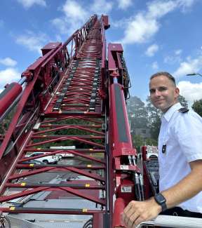 German firefighter Sven poses by extended leddar on ladder truck