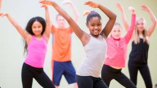 a group of young dancers with hands in the air