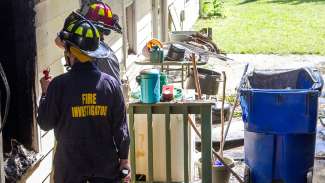 Two firefighters investigating a burned out section of a building