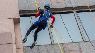 Chief Patterson in action as she rappels down the Wells Fargo building for Special Olympics.