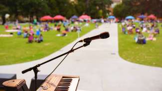 an image of a microphone with picnickers in the background