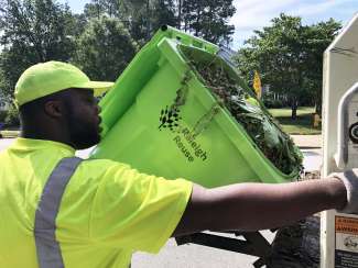 SWS personnel servicing a yard waste cart