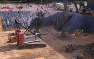 Shows crane drilling the test pile 
