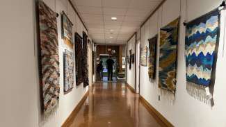 long hallway with fiber artworks on display