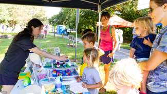 people visiting a vendor at mud day with building brick toys