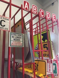 Raleigh DOT Sign Shop rack with brightly colored traffic signs . 