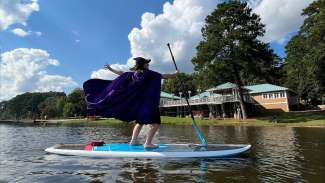 a person dressed up as a witch on a paddle board 