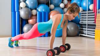 a teenager wearing workout clothes while doing dumbbell pushups