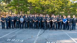 Raleigh police stand in a circle to have a briefing before deploying to western NC to help after Hurricane Helene