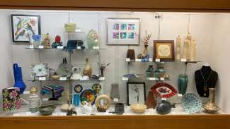 Display cases with jewelry and framed artwork hanging on the wall. 