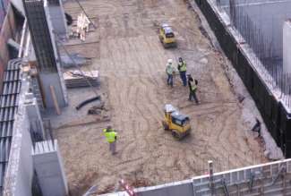 image shows construction site and trench roller being used