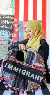 Women with a yelllow headscarf holds artwork 