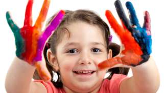 a child showing off her finger paint hands