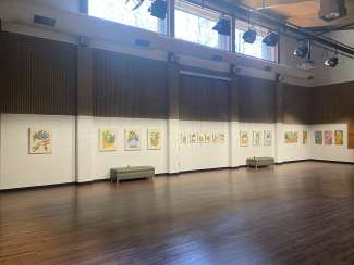 artworks hanging on the wall in a large room with white walls and a wooden floors 