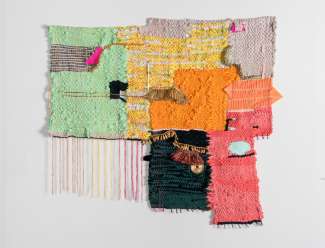 Woven fiber with bright colors hung on wall.