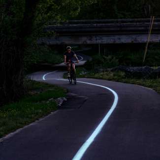 Biker on glowing greenway