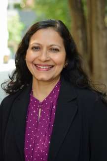 Photo of Dhanya Sandeep standing outside with trees behind her