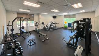An indoor fitness room with equipment and a stretching station at Marsh Creek