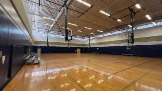 An open gymnasium with multiple courts and basketball hoops 