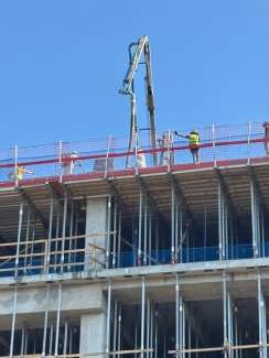 Close up image of construction activity taking place on the City Hall building, shows the concrete floor being poured. 