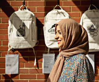 Artist Kulsum Tasnif poses in front of backpacks at Method Park