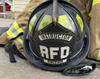 A close-up of a Fire Academy instructor's helmet which says "Instructor RFD Raleigh"