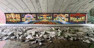 A colorful mural on the tunnel wall references the imagery of illuminated manuscripts.
