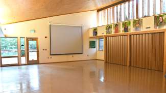 A large open room with lots of windows and a pull-down projector 