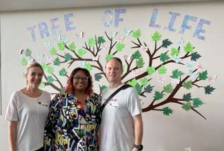 Ingrams stand with Reid in front of the Tree of Life wall in the 911 call center