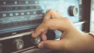hand adjusting the button vintage radio receiver