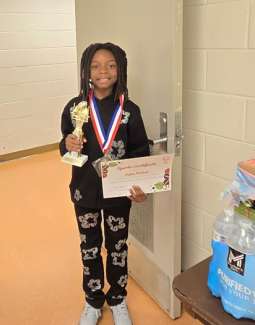 a boy holding an award