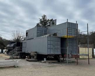 a structure that looks like four metal shipping containers- two on the "first floor" and two on the "second floor". The structure has mutliple entranes and front stairs