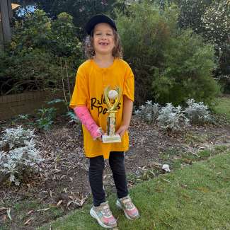 a t ball player holding a trophy 