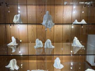 White porcelain figures in a glass case 