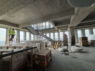 image of inside City Hall looking at staircase and outside view through windows.