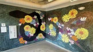 Snake wrapping around wall surrounded by flowers and words