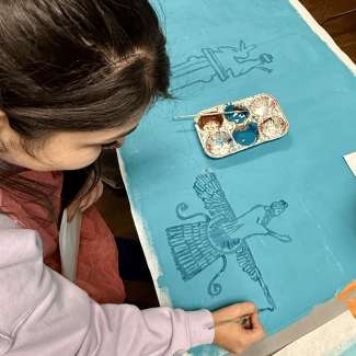 a child doing a craft using blue paper and paint