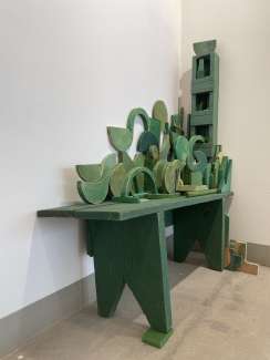 A series of green painted wood scraps assembled to make a sculpture