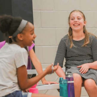 Kids laughing and talking in a gym